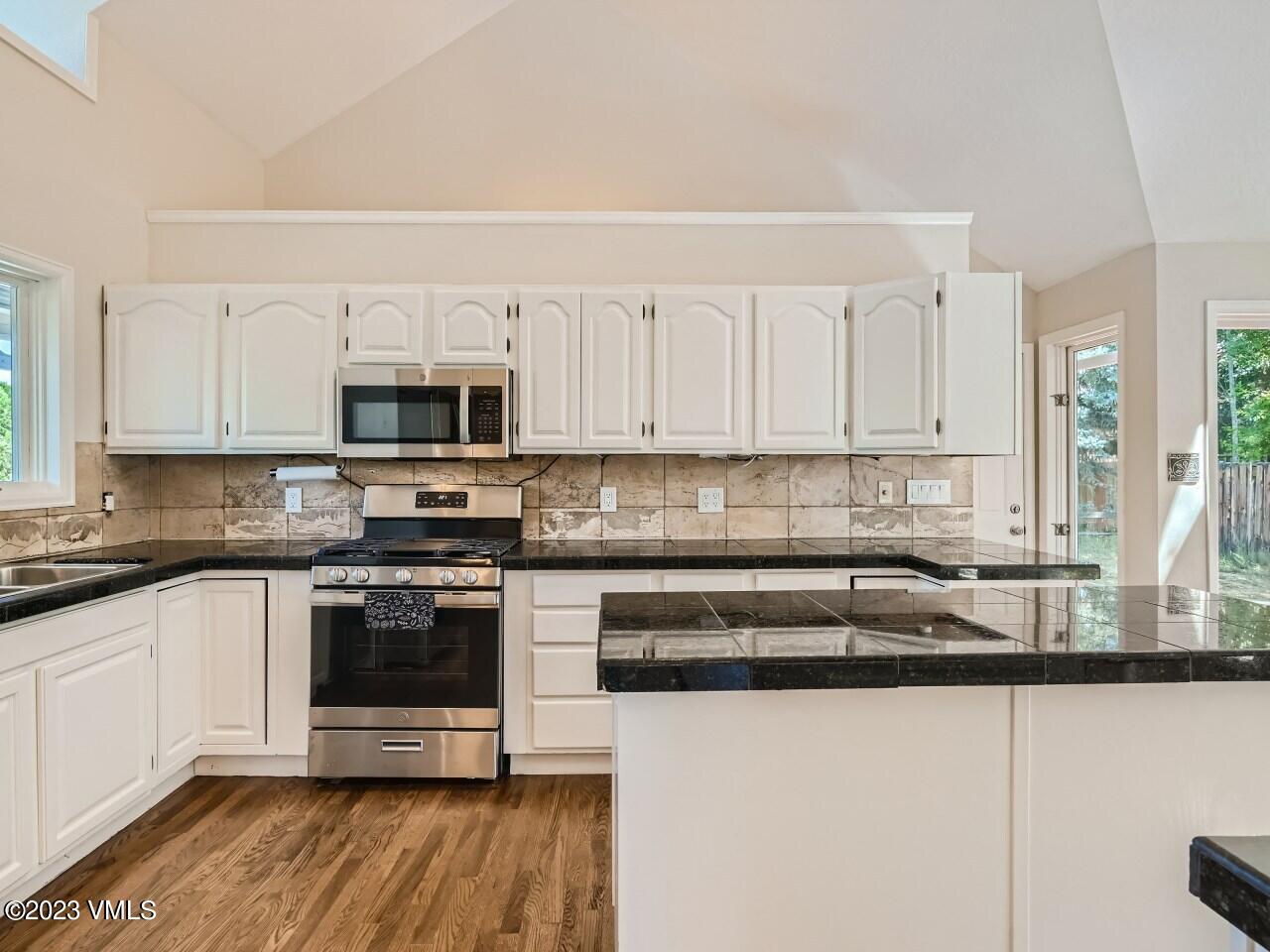 25 Snow Owl Eagle, CO 81631 - Photo 10 of 37 a kitchen with stainless steel appliances granite countertop a stove a sink and a microwave