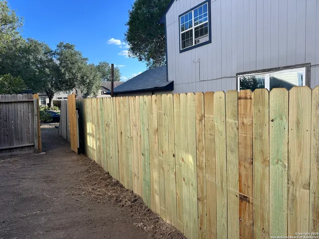a view of a backyard with wooden fence