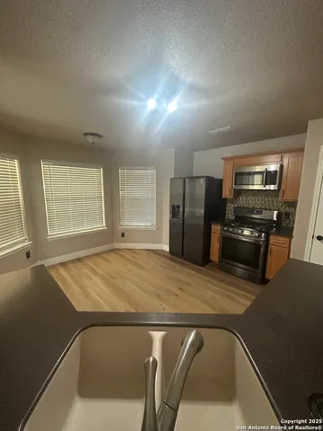 a kitchen with a refrigerator and a stove top oven
