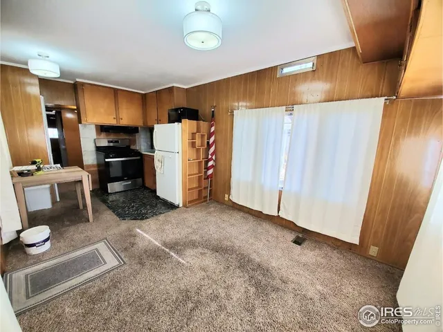 a view of a kitchen with refrigerator and wooden floor