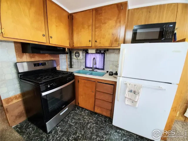 a kitchen with stainless steel appliances granite countertop a stove a microwave and a refrigerator