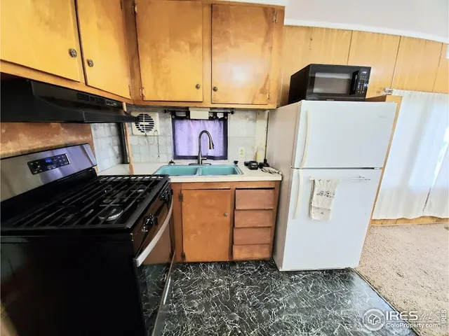 a kitchen with stainless steel appliances a refrigerator a stove and a cabinets