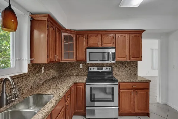a kitchen with stainless steel appliances granite countertop a sink stove and cabinets