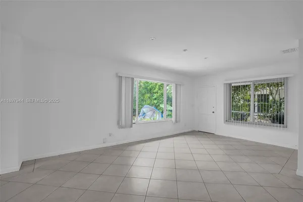 an empty room with windows and closet