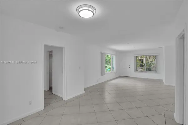 a view of an empty room with a ceiling fan and a window