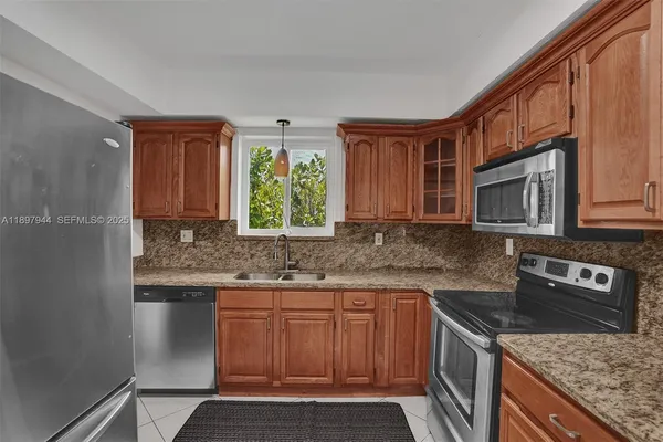 a kitchen with stainless steel appliances granite countertop a stove sink microwave and cabinets