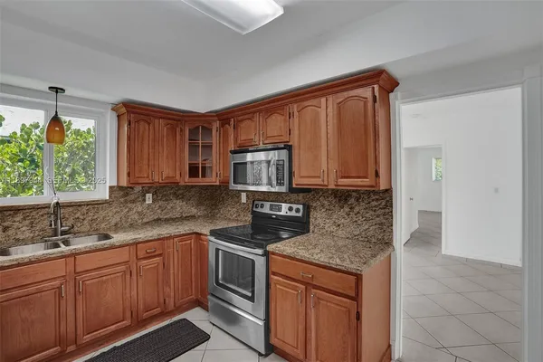 a kitchen with stainless steel appliances granite countertop a sink stove and cabinets