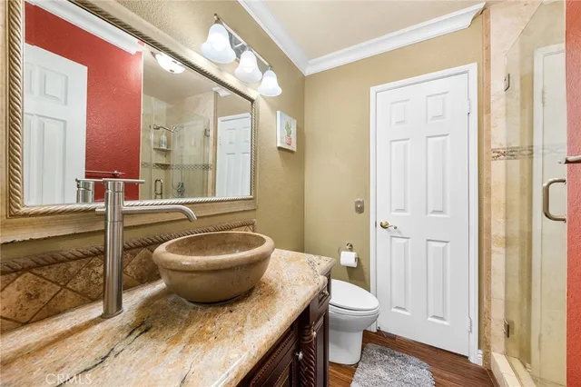 a bathroom with a granite countertop toilet a sink and a mirror
