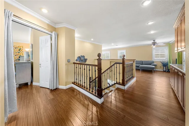 a view of a hallway with wooden floor and windows