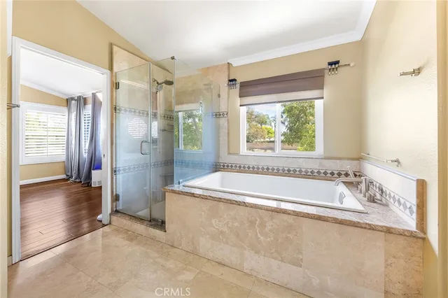 a spacious bathroom with a tub shower and windows