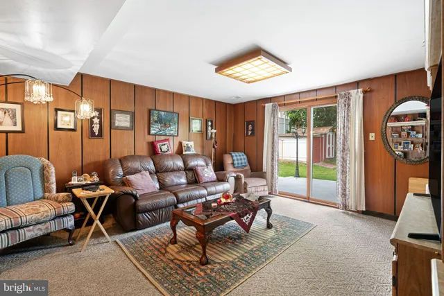 a living room with furniture a rug potted plant and a large window
