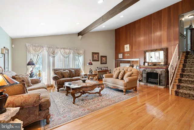 a living room with furniture kitchen view and a large window