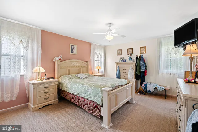 a spacious bedroom with a bed and a tv