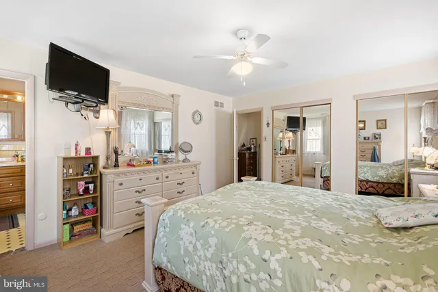 a spacious bedroom with a bed and a flat screen tv