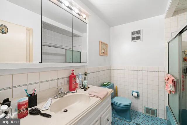 a bathroom with a sink mirror vanity and toilet
