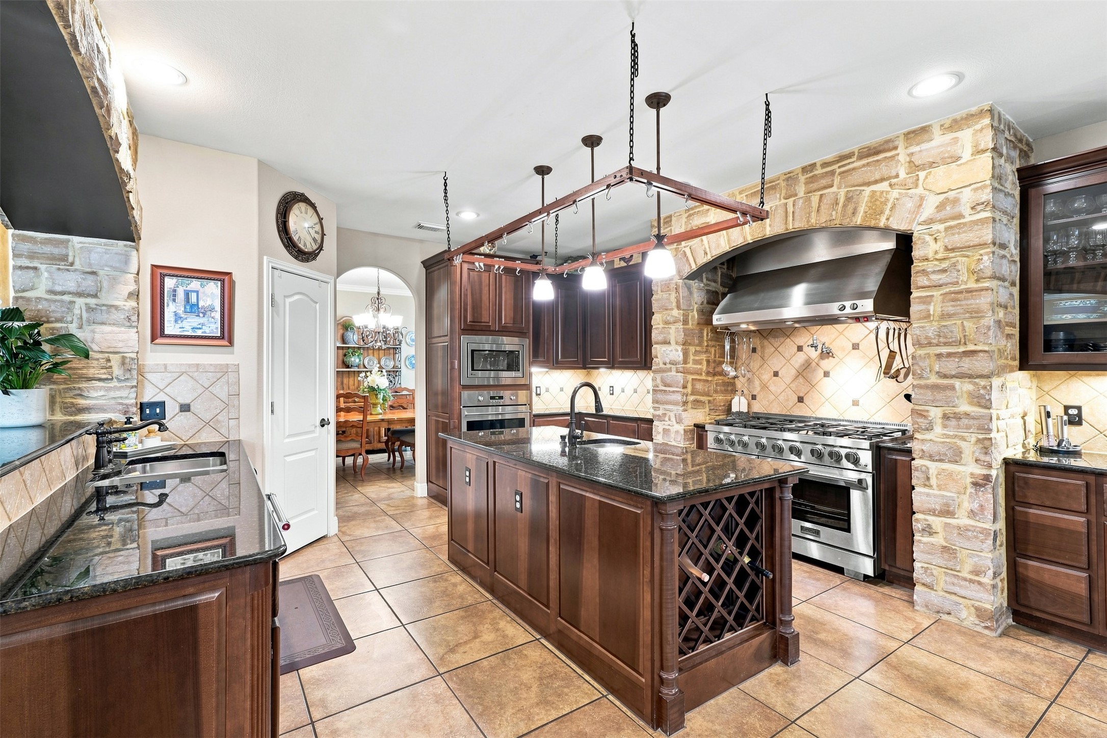 402 Ridgetop Bend Cedar Park, TX 78613 - Photo 16 of 40 A stone arch frames the professional gas range in this tiled kitchen with center island.