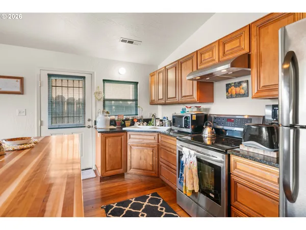 a kitchen with stainless steel appliances granite countertop a stove a sink and a microwave