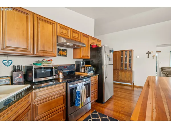 a kitchen with stainless steel appliances granite countertop a refrigerator a stove and a sink