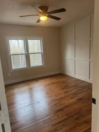 a view of empty room with wooden floor