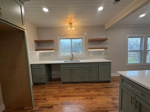 a kitchen with kitchen island a sink stainless steel appliances and cabinets