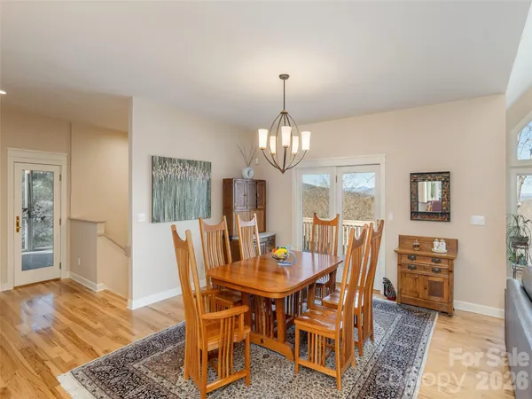 a dining room with furniture a chandelier and wooden floor