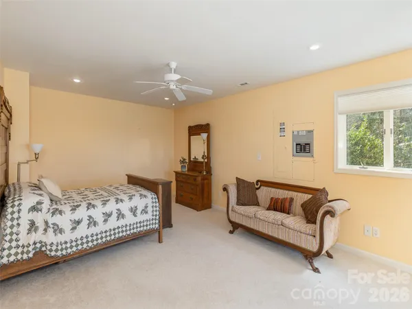 a bedroom with a bed and a dresser with mirror