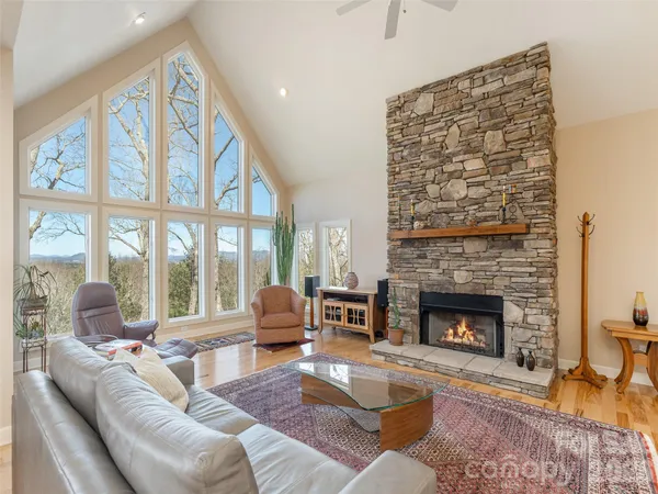a living room with furniture a fireplace and a floor to ceiling window