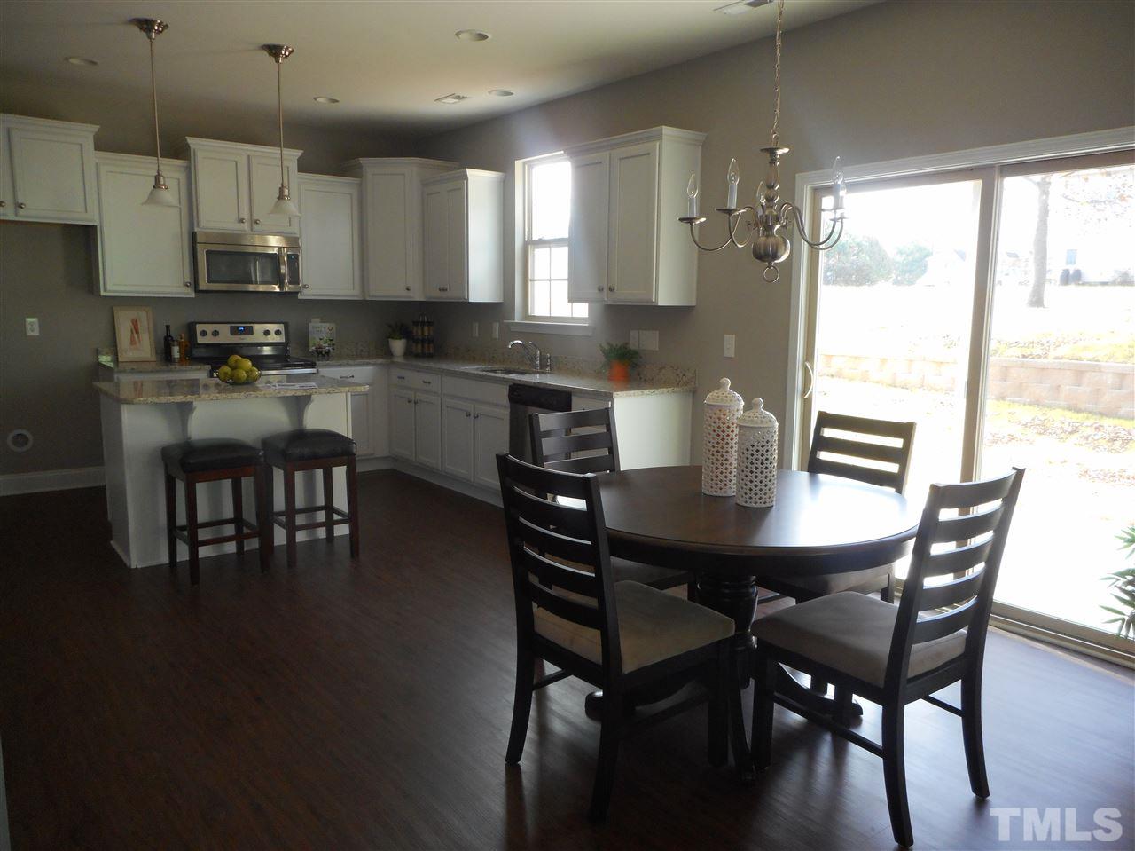 1509 Bentons Ridge Drive Raleigh, NC 27610 - Photo 12 of 23 a kitchen with a dining table chairs and window