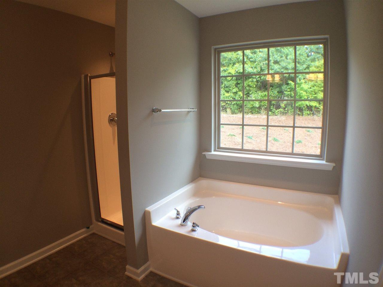 1509 Bentons Ridge Drive Raleigh, NC 27610 - Photo 18 of 23 a white bath tub sitting in a bathroom next to a window