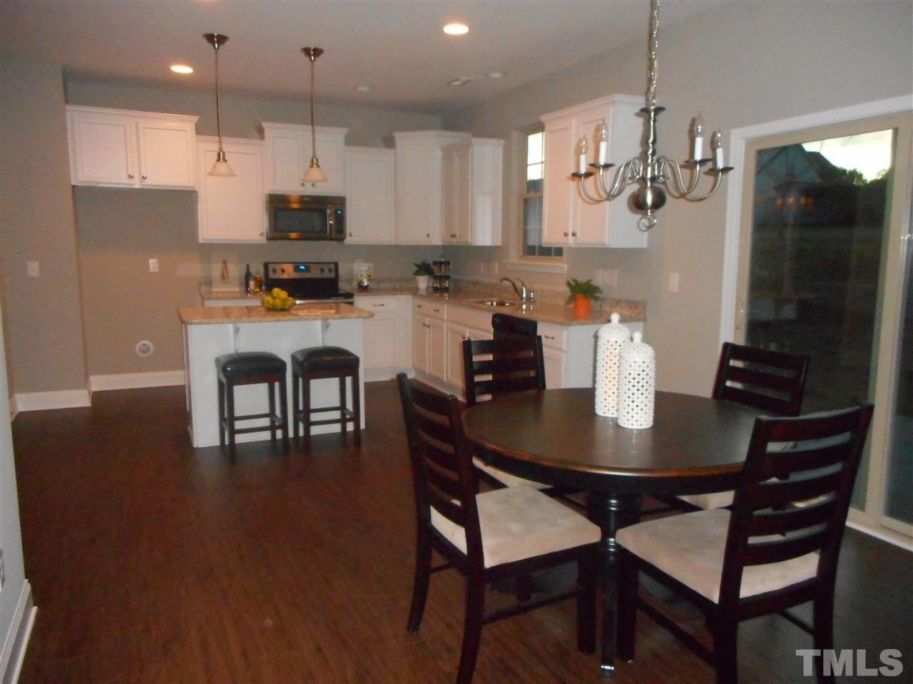 1509 Bentons Ridge Drive Raleigh, NC 27610 - Photo 4 of 23 a kitchen with kitchen island a dining table and chairs