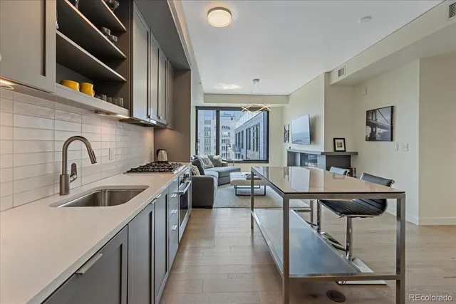 a kitchen with sink a refrigerator and chairs