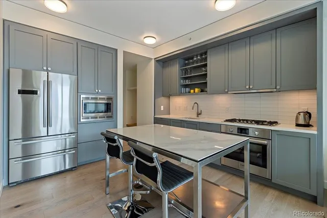 a kitchen with kitchen island a sink stove and refrigerator