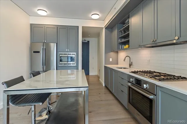 a kitchen with stainless steel appliances granite countertop a stove a sink and a refrigerator