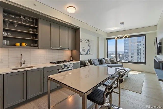a kitchen with a stove a sink a dining table and chairs