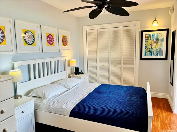 a bedroom with a bed and a painting on the wall
