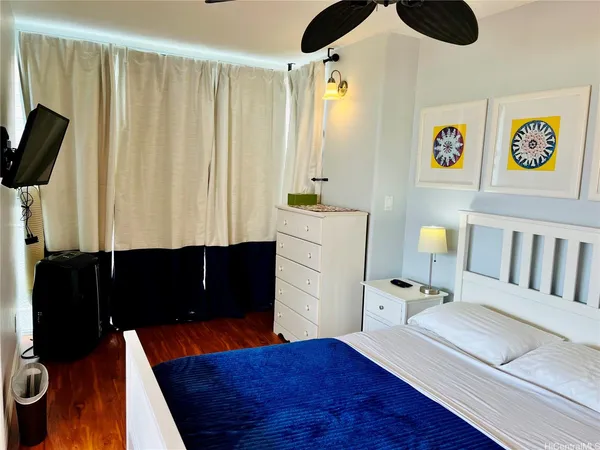 a bedroom with a bed and wooden floor