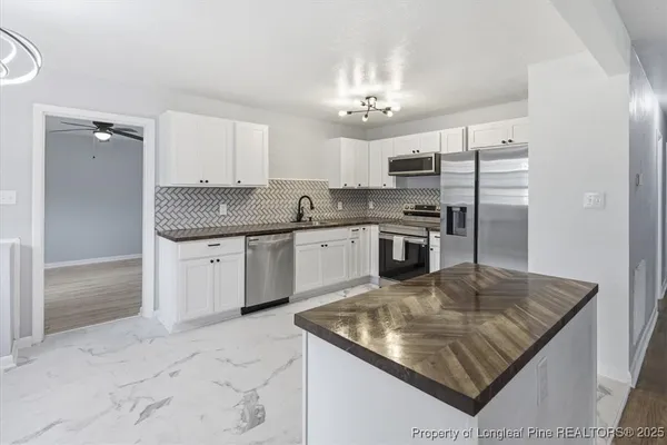 a kitchen with a sink a center island and cabinets