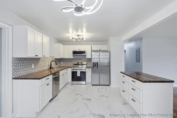 a large kitchen with stainless steel appliances kitchen island granite countertop a sink and cabinets