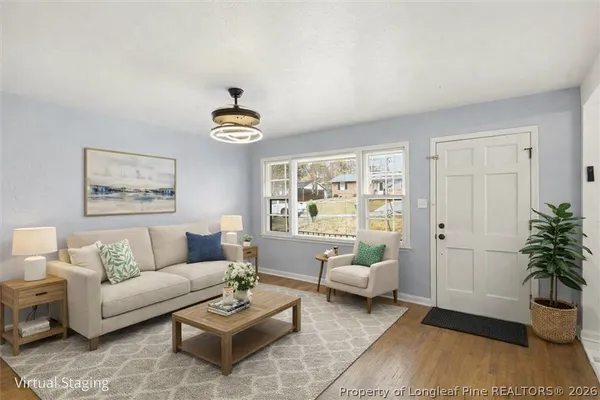 a living room with furniture a rug and a window