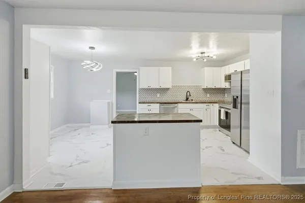 a kitchen with granite countertop a sink and cabinets