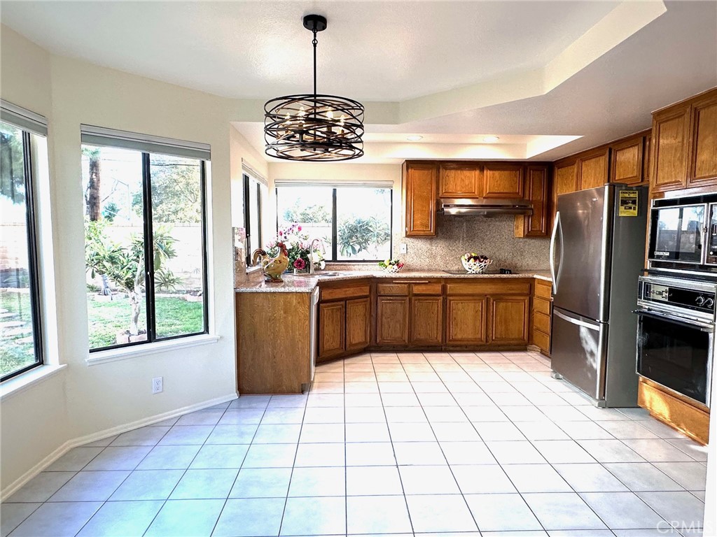 183 South Starflower Street Brea, CA 92821 - Photo 13 of 42 a kitchen with stainless steel appliances a sink a stove a refrigerator cabinets and a large window