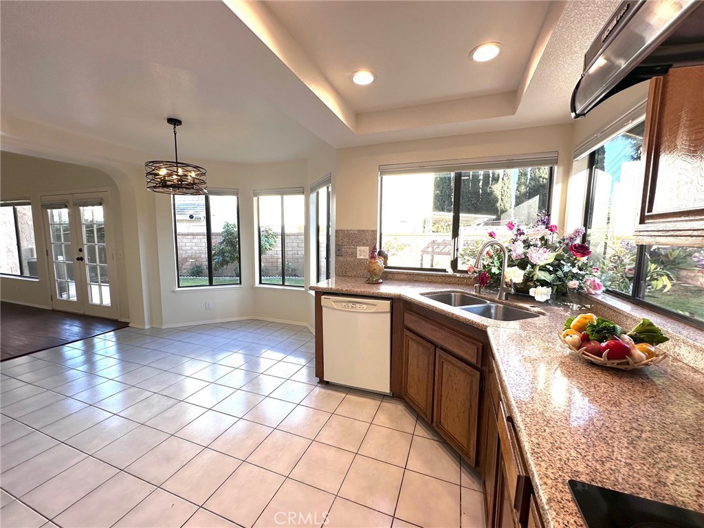 183 South Starflower Street Brea, CA 92821 - Photo 15 of 42 a kitchen with granite countertop a stove dining table chairs and a chandelier
