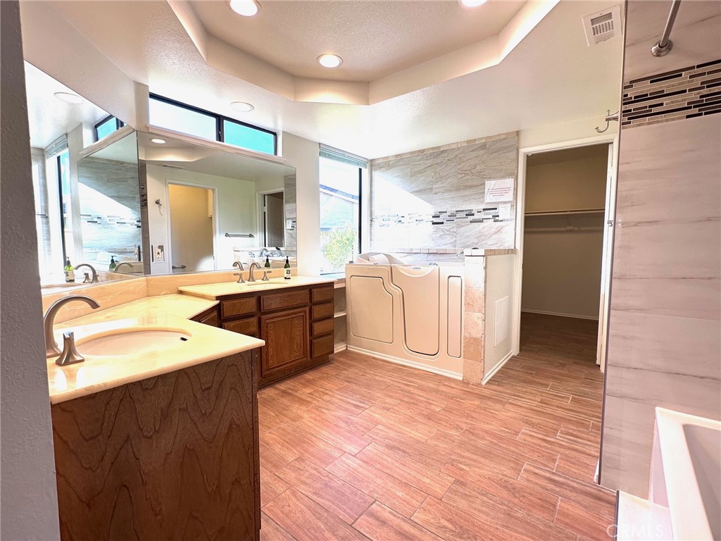 183 South Starflower Street Brea, CA 92821 - Photo 18 of 42 a large bathroom with a double vanity sink a mirror and a bathtub