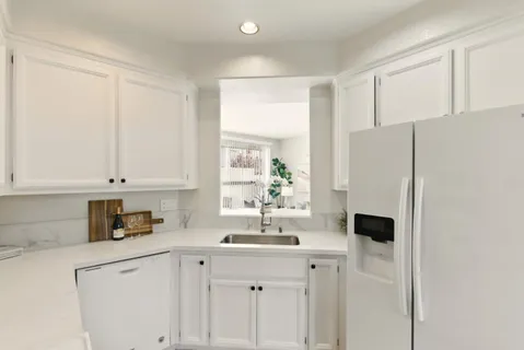 a kitchen with a sink a refrigerator and cabinets