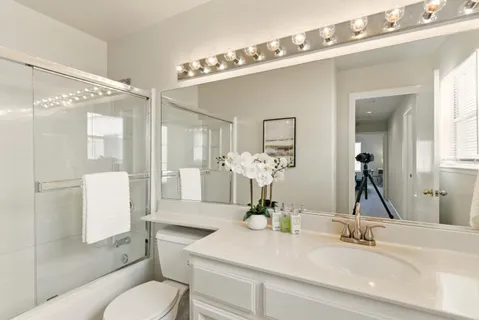 a bathroom with a toilet a sink and a mirror