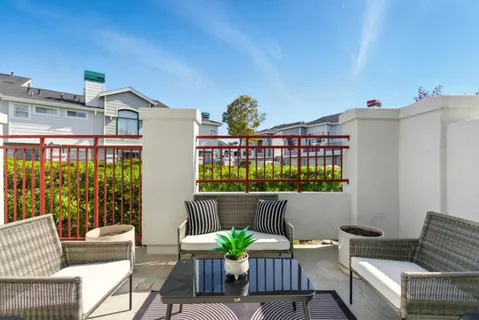a view of a patio with couches table and chairs with potted plants