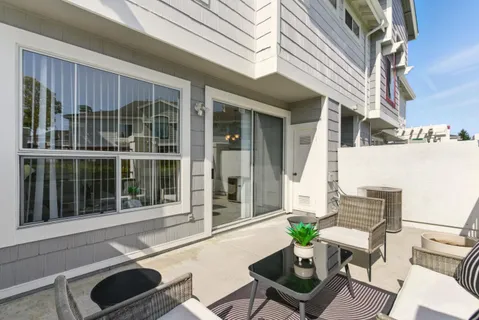 a view of a patio with couches table and chairs and potted plants