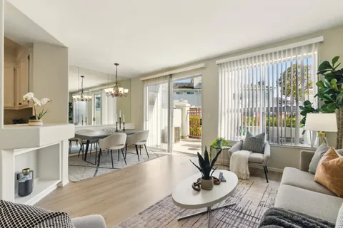 a living room with furniture a dining table and a potted plant