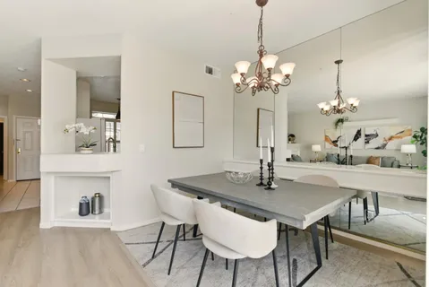 a view of a dining room with furniture a chandelier and wooden floor