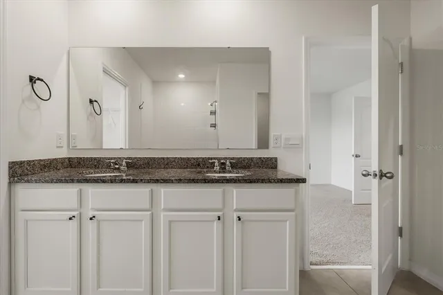 a bathroom with a granite countertop sink and a mirror